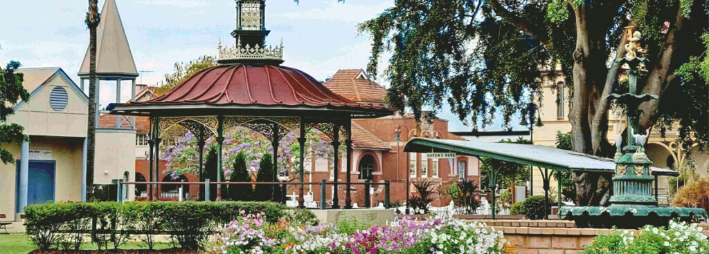 Queen’s Park’s historic Band Rotunda anchors a landscape of gardens, heritage architecture and community life.