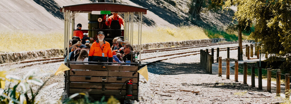 Passengers riding an open-air train carriage