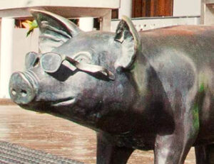 Bronze pig sculpture wearing sunglasses